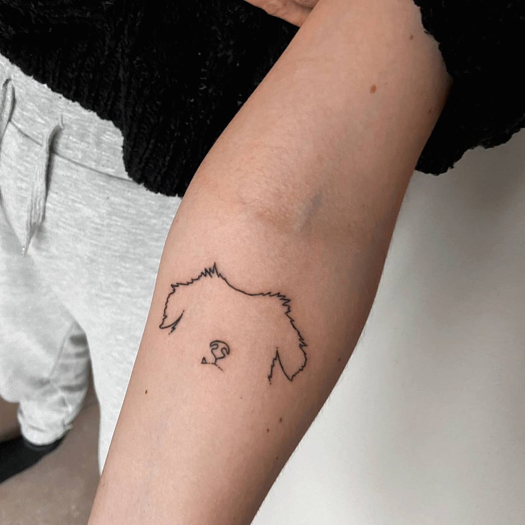 Minimalist dog tattoo on the inner arm