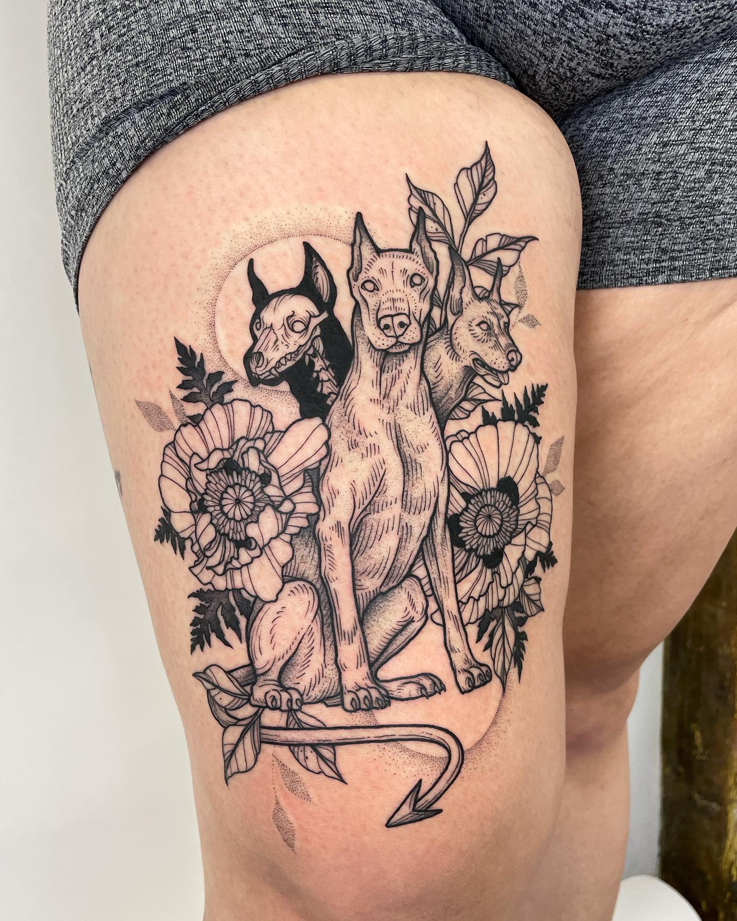 Here is the fantastic Cerberus tattoo that is surrounded by poppies and vines.