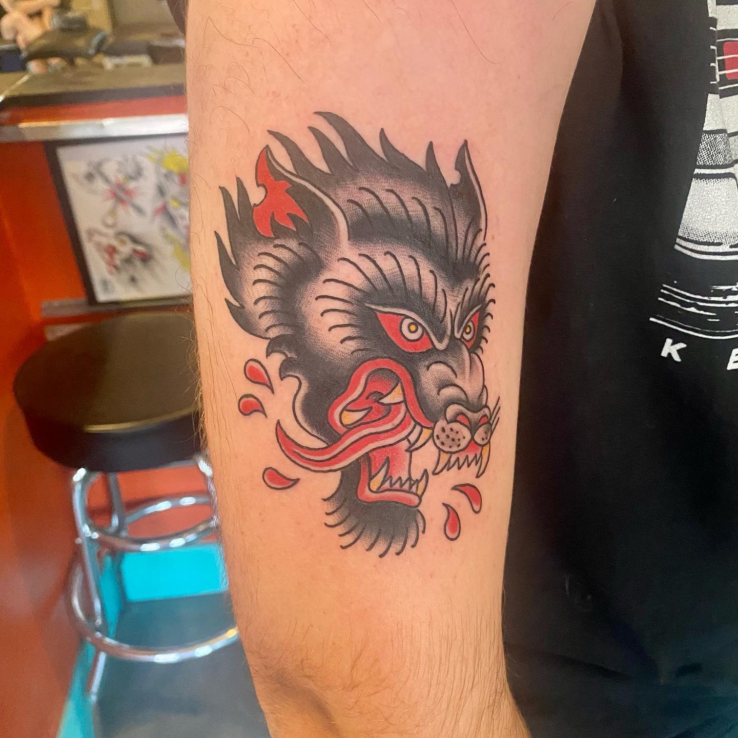 A savage wolf tattoo with red and black vibes. These blood drops make it more brutal.