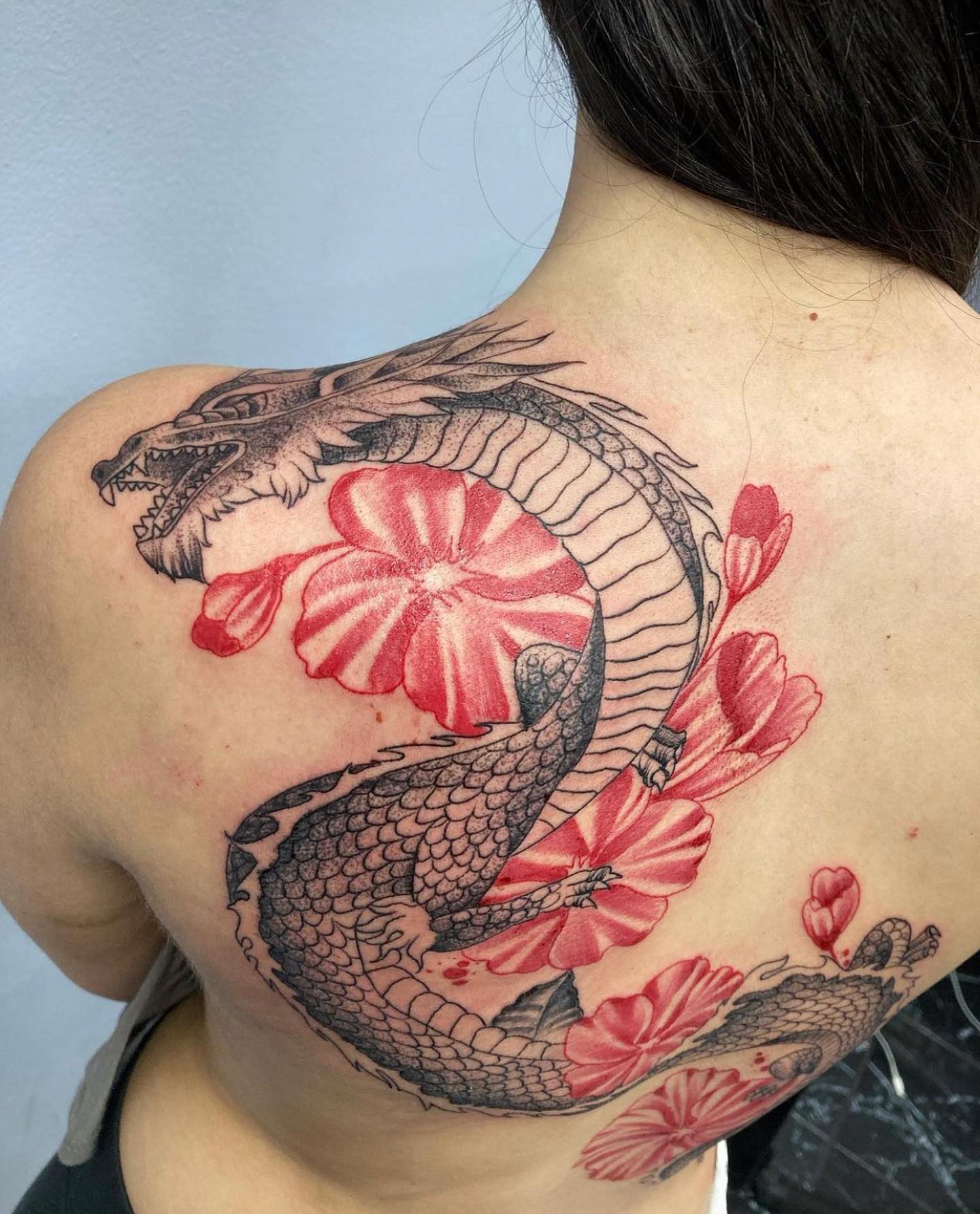 Show that you’re a bold young lady with this kimono dragon tattoo done in both black and red elements.