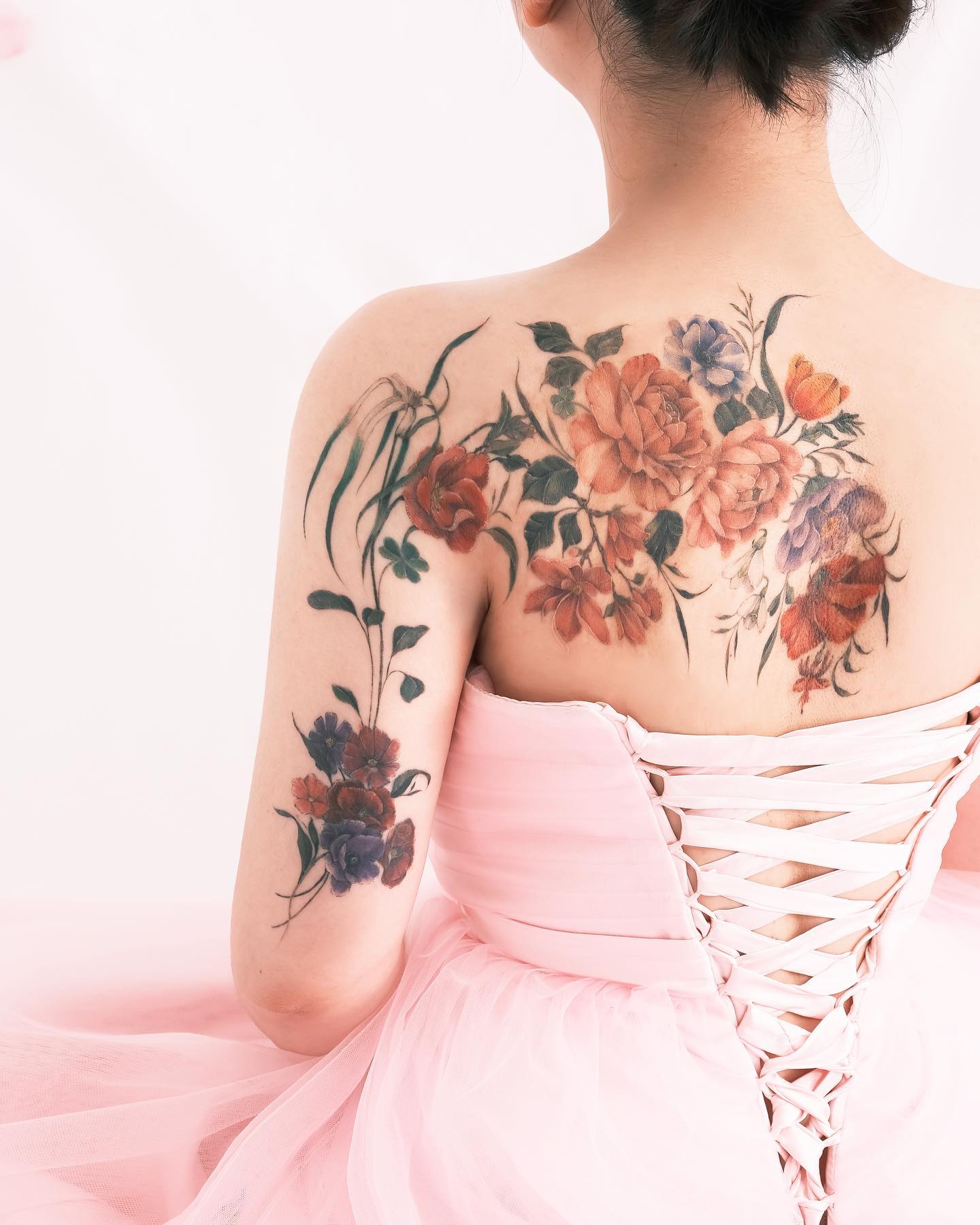Fun flowers such as these will show that you’re soft, feminine, and romantic. Women who are into fun and bright, as well as artsy designs, will adore this option across their backs.