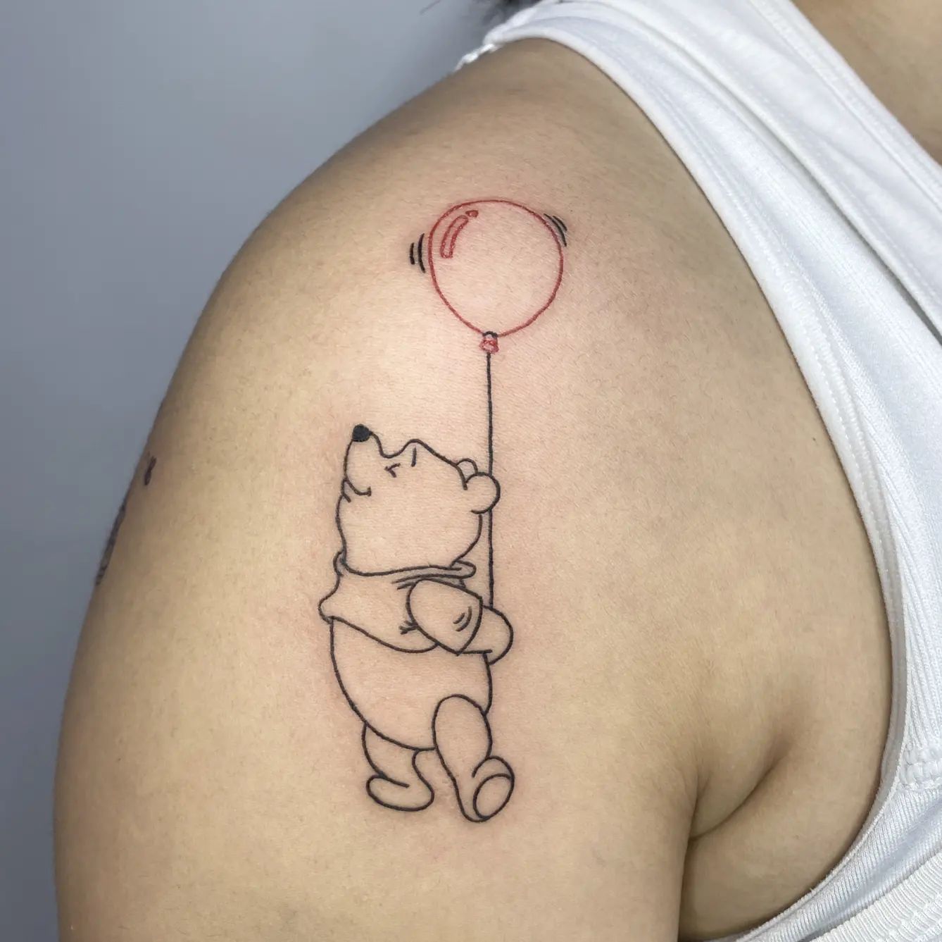 If Winnie was your favorite character while growing up you’re going to like this cute and small black ink shoulder tattoo.