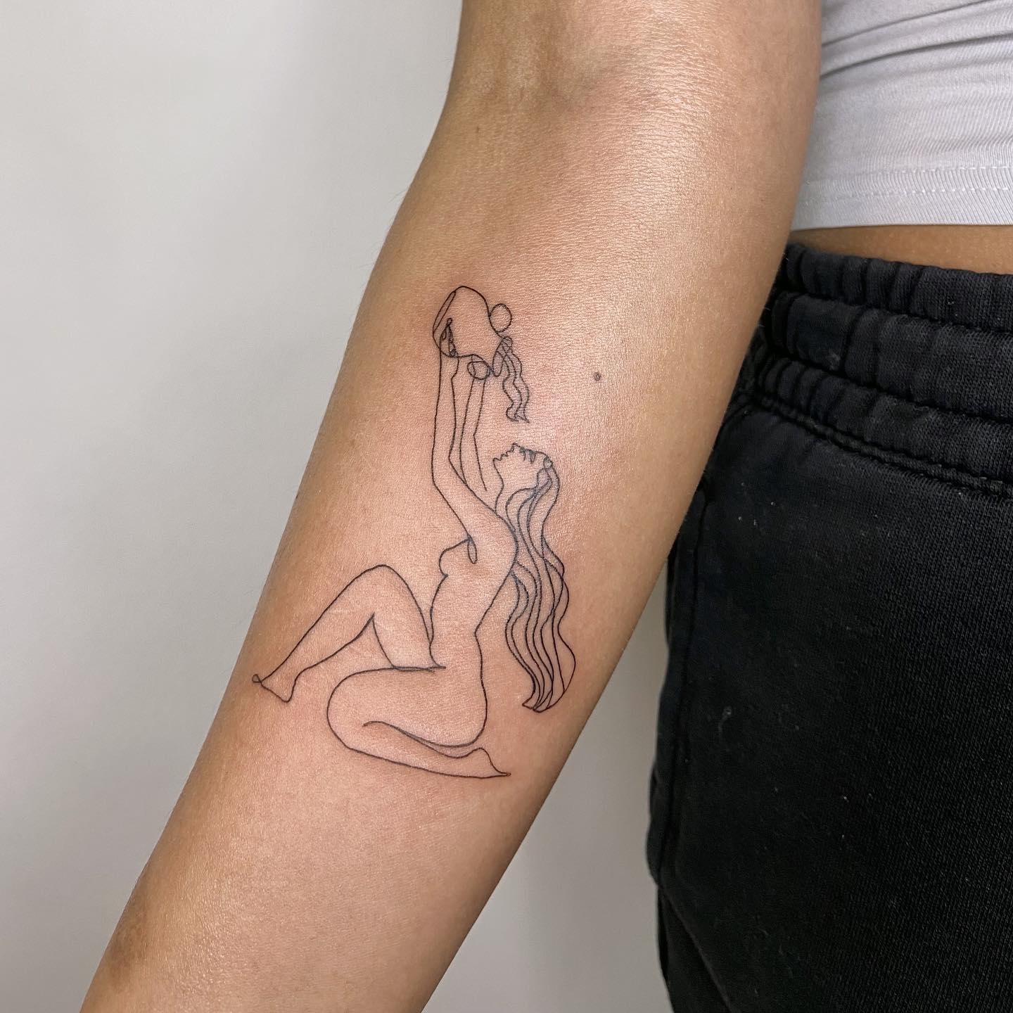 In line art tattoos, marks are used to create images and they offer a perfect look. A naked woman is pouring some water into her mouth in this tattoo design. Her hair is in the shape of water waves, which looks amazing. If you like minimalist tattoos, this is the one you should go for.