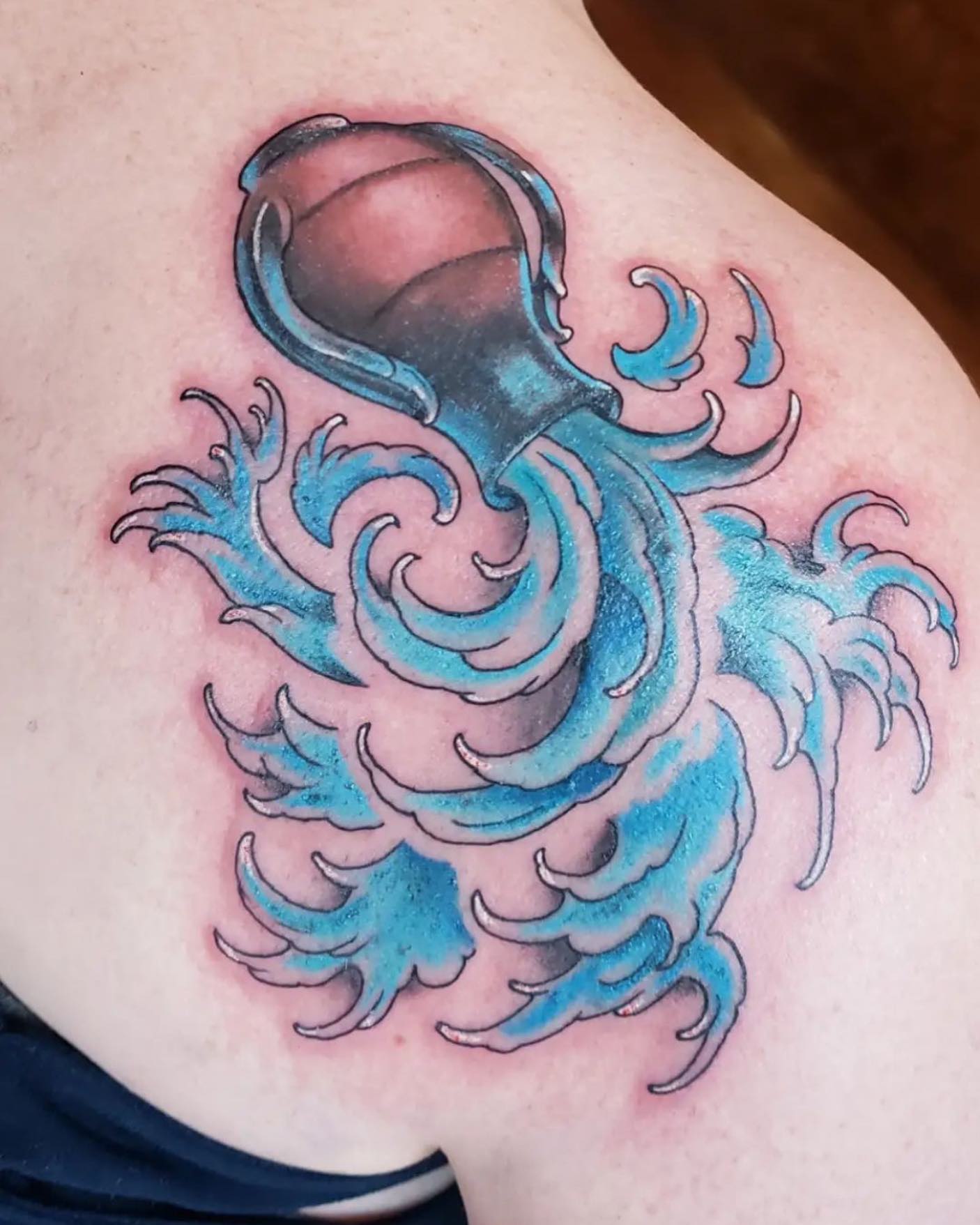 Water drops are all over the place! This tattoo may give the meaning that you, as an Aquarius person, spread kindness to everyone you come across with. It could be a nice tattoo to get to show your horoscope to everyone aroun you. Blue ink gives it a different and great look by the way.