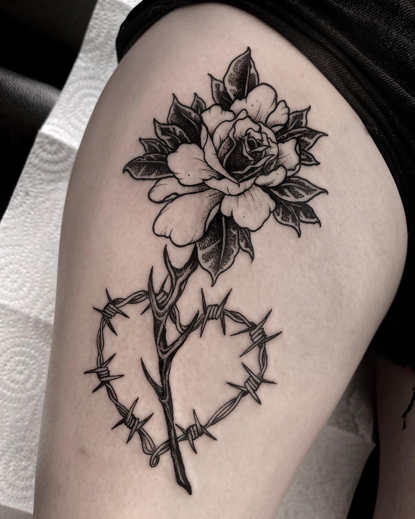 Rose thorns represent that nothing is perfect. Every beautiful thing in this world has a negative side and we should all be aware of that. In this tattoo, heart shape barbed wire is combined with rose thorns. The barbs and thorns may symbolize that every love is not perfect.