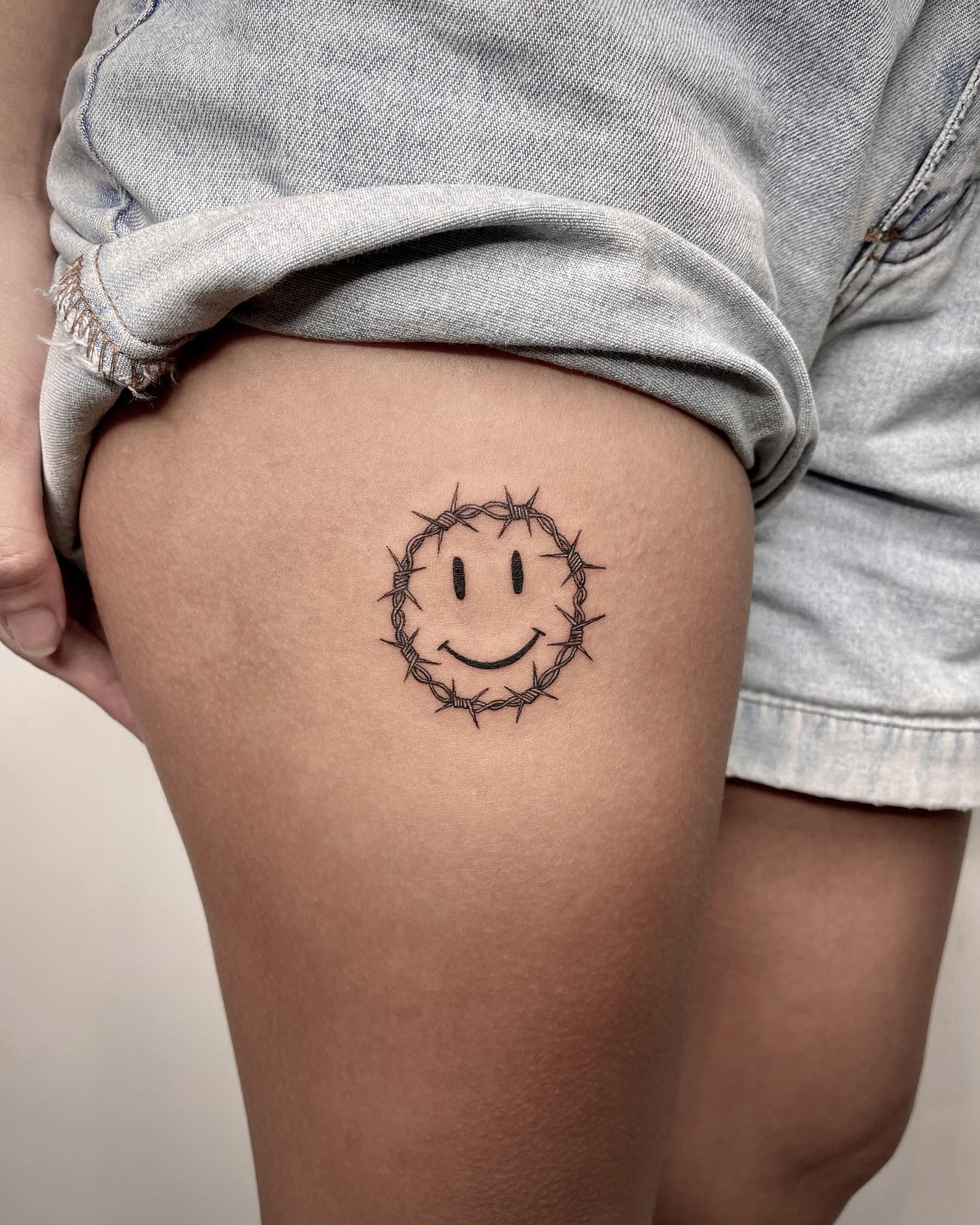 Pain is not an optional thing and people do not choose to feel it. However, there is something that you can choose: Happiness. If you choose it, you will feel better and you know what? Your pain will get easier to bear. Get this smiley tattoo with barbed wires for it.