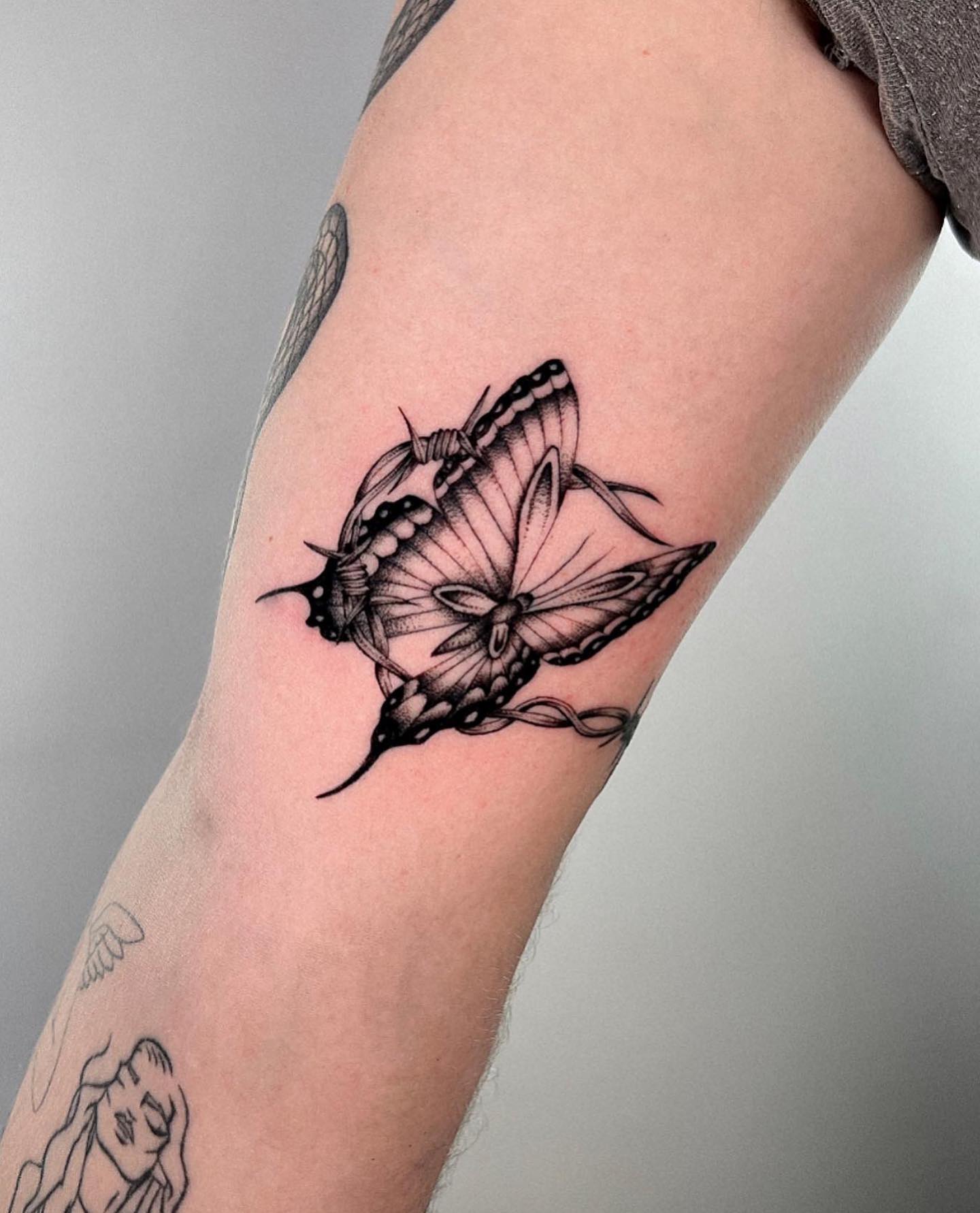 It is definitely a tattoo done by a great tattooist. The details of butterfly and barbed wire make this artwork look so real that it makes you to touch to see if it is real. The barbed wire surrounds the butterfly and protects it from any damage since it is a very delicate animal.