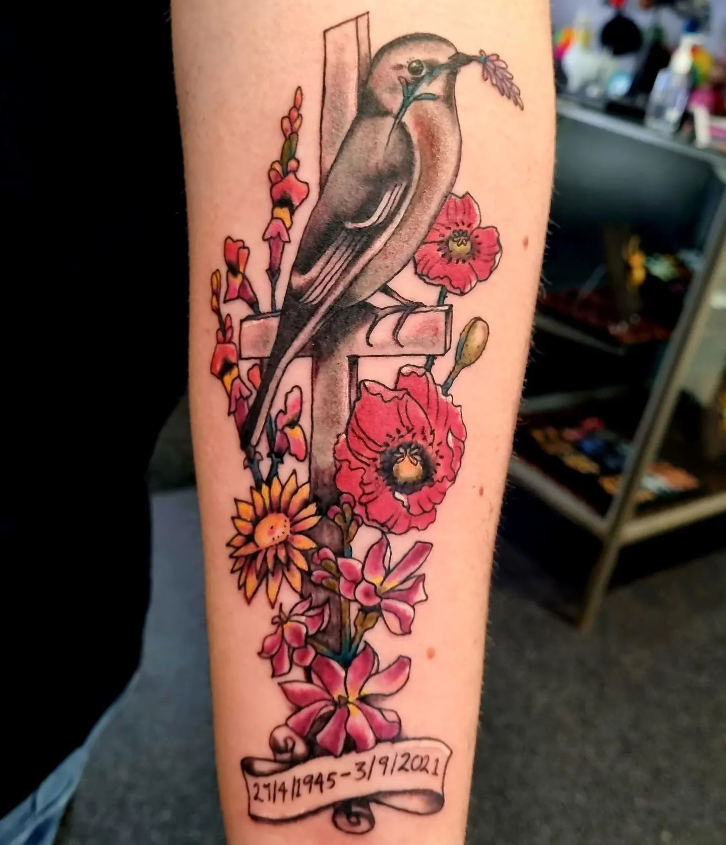 Death is unstoppable and it comes when we are not prepared. Losing someone we love is painful but you can keep them alive on your body thanks to tattoos! A cross with a sign of birth and death date looks great with some colorful flowers. Especially, this bird is ready to protect the cross.