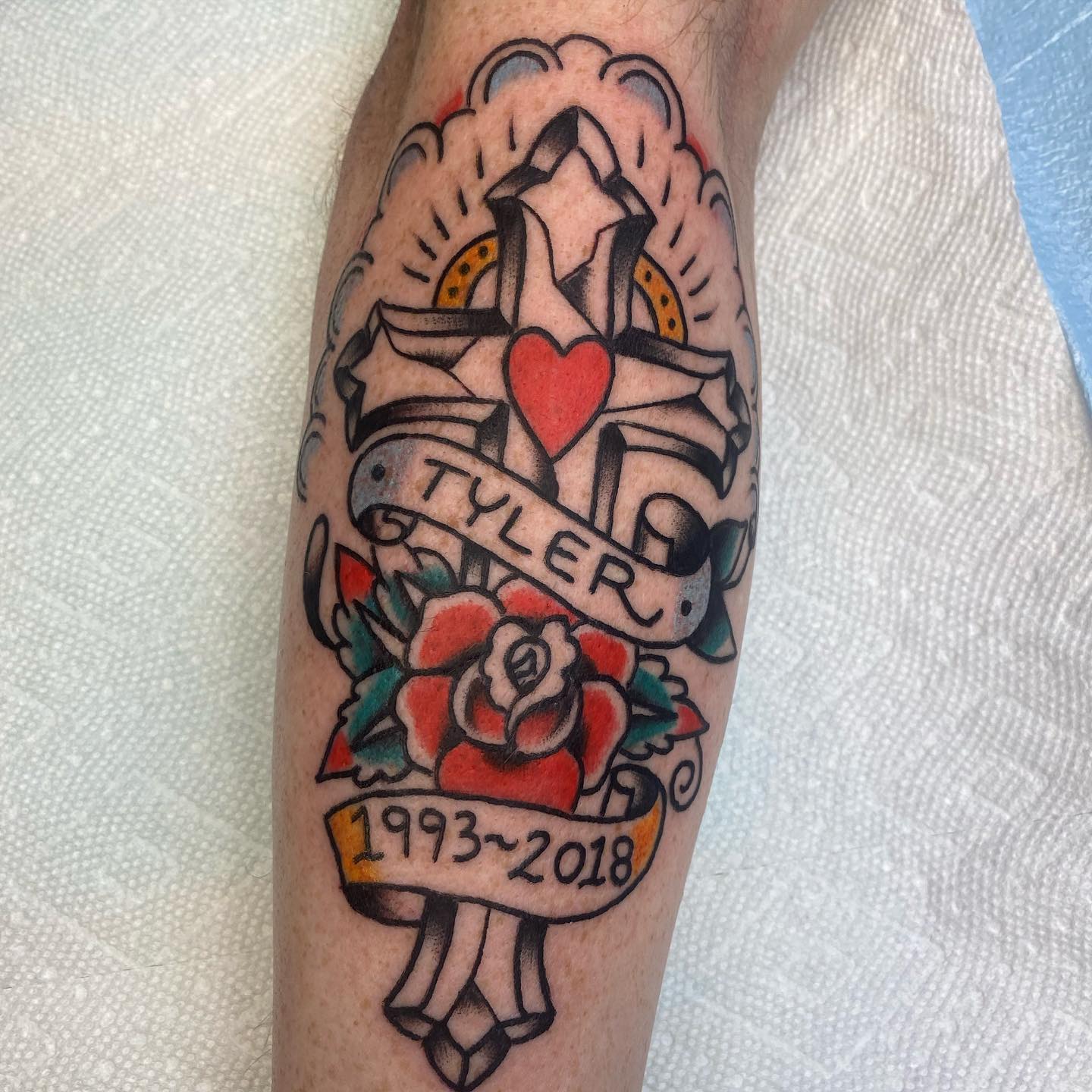 Memorial tattoos allow people to keep their loved ones on their body forever. In order to symbolize that you send your loved one to heaven, let's get a cross tattoo with a red rose and honor them in a perfect way.