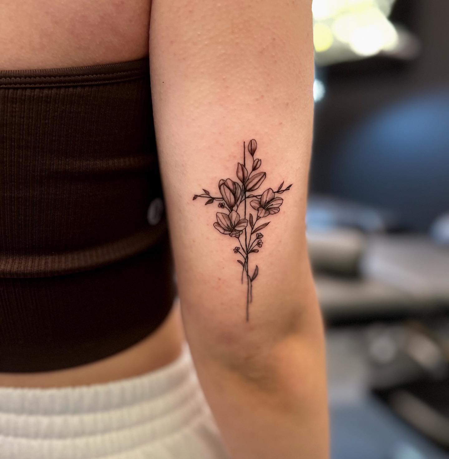 Did you know that in ancient cultures, flowers were used as a symbol of god's contentment? This meaning makes it a perfect choice for a cross tattoo. A thin line of cross is decorated with flowers above and it looks adorable. Go for it.