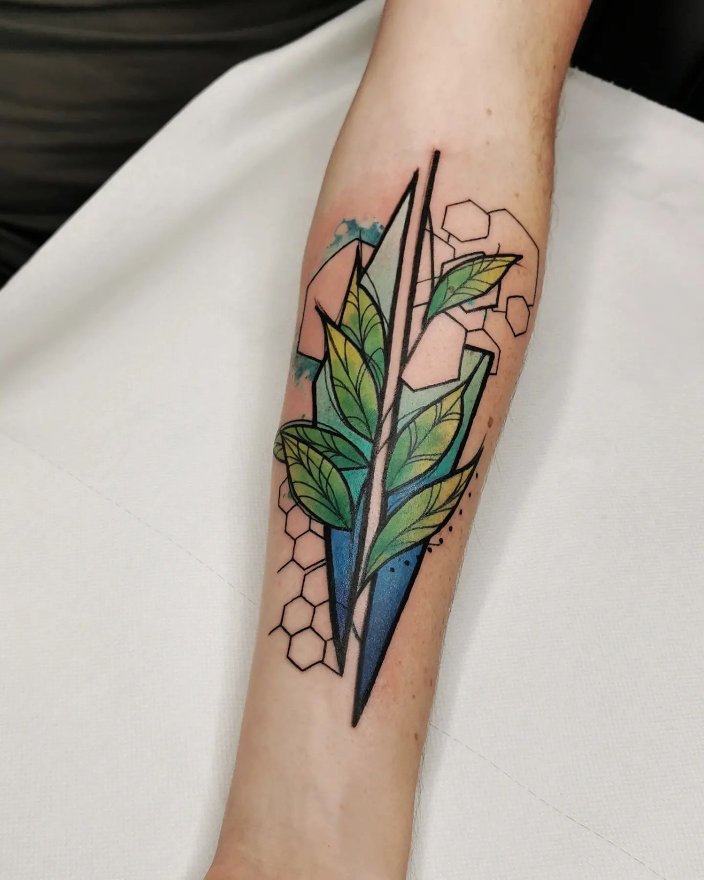 With its colorful palette, this graphic and abstract leaf tattoo offers a great look. These shapes add an extra beauty, too. You should definitely go and get it.