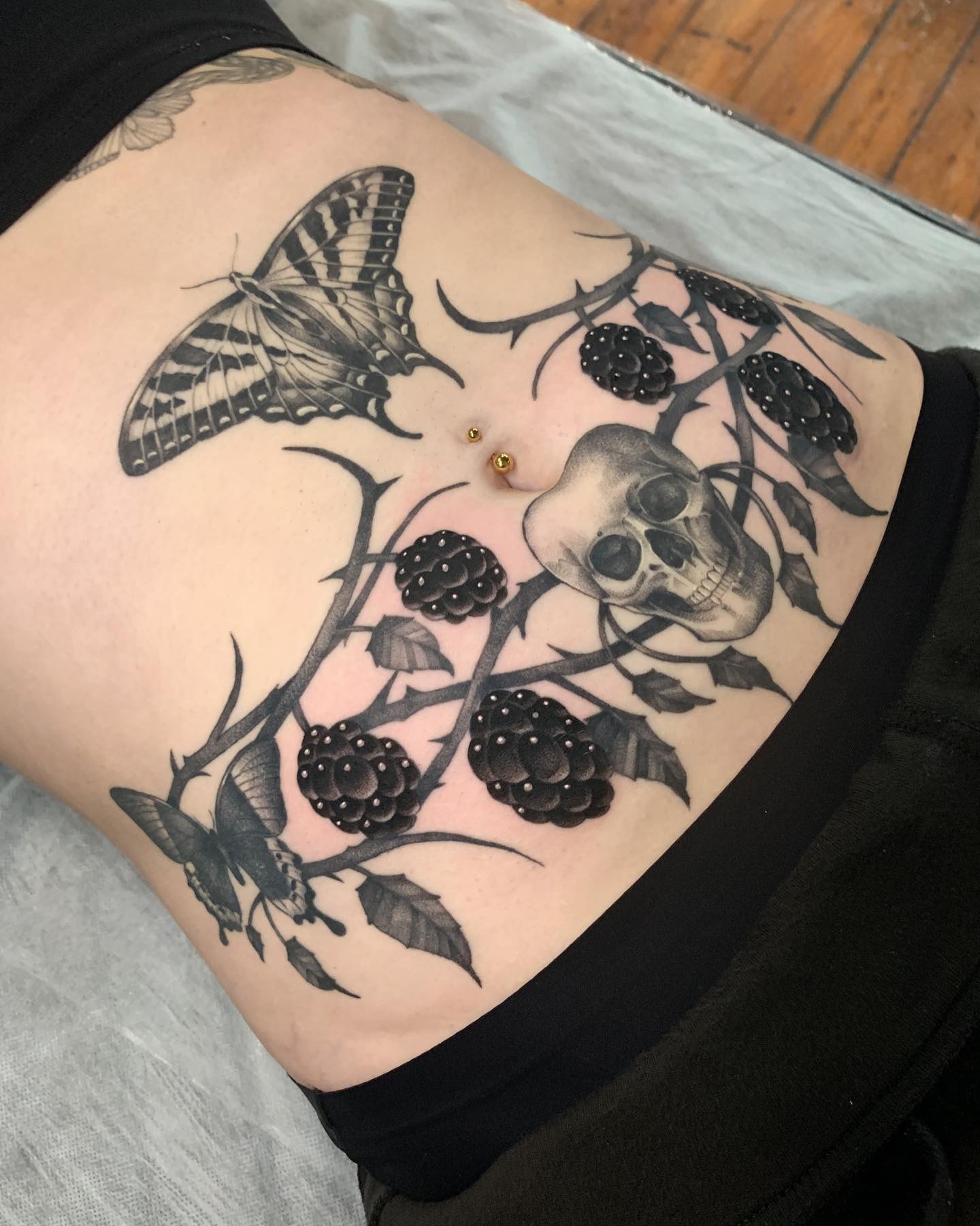 Why don't you try something bolder on your skin? Those who like gothic tattoos will definitely go for this leaf tattoo that is combined with berries and butterflies. It looks like a darker side of nature.