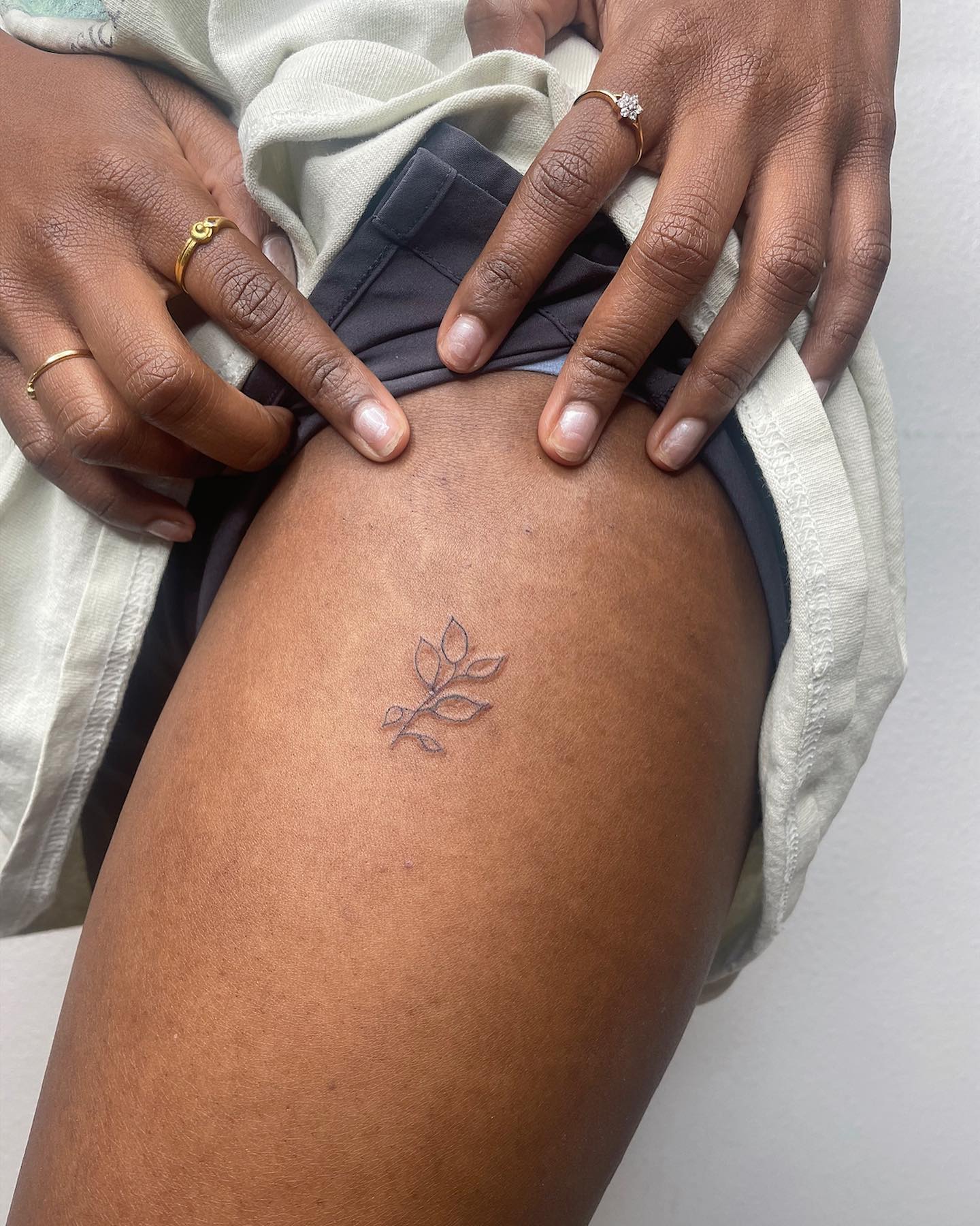 Why don’t you make your upper leg shine out with this tattoo? Super-small leaf tattoo is enough to look perfect since minimalist tattoos are also super cool.