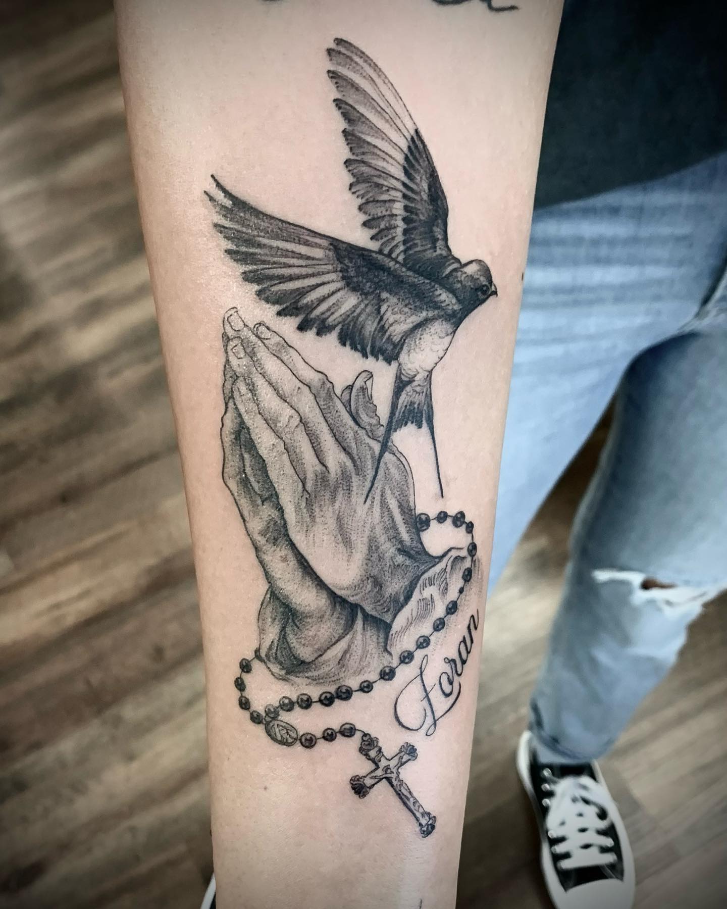 With that cute bird, this tattoo will stand out on your arm. Bird symbolizes freedom and peace, so it is quite matching with your praying hands.