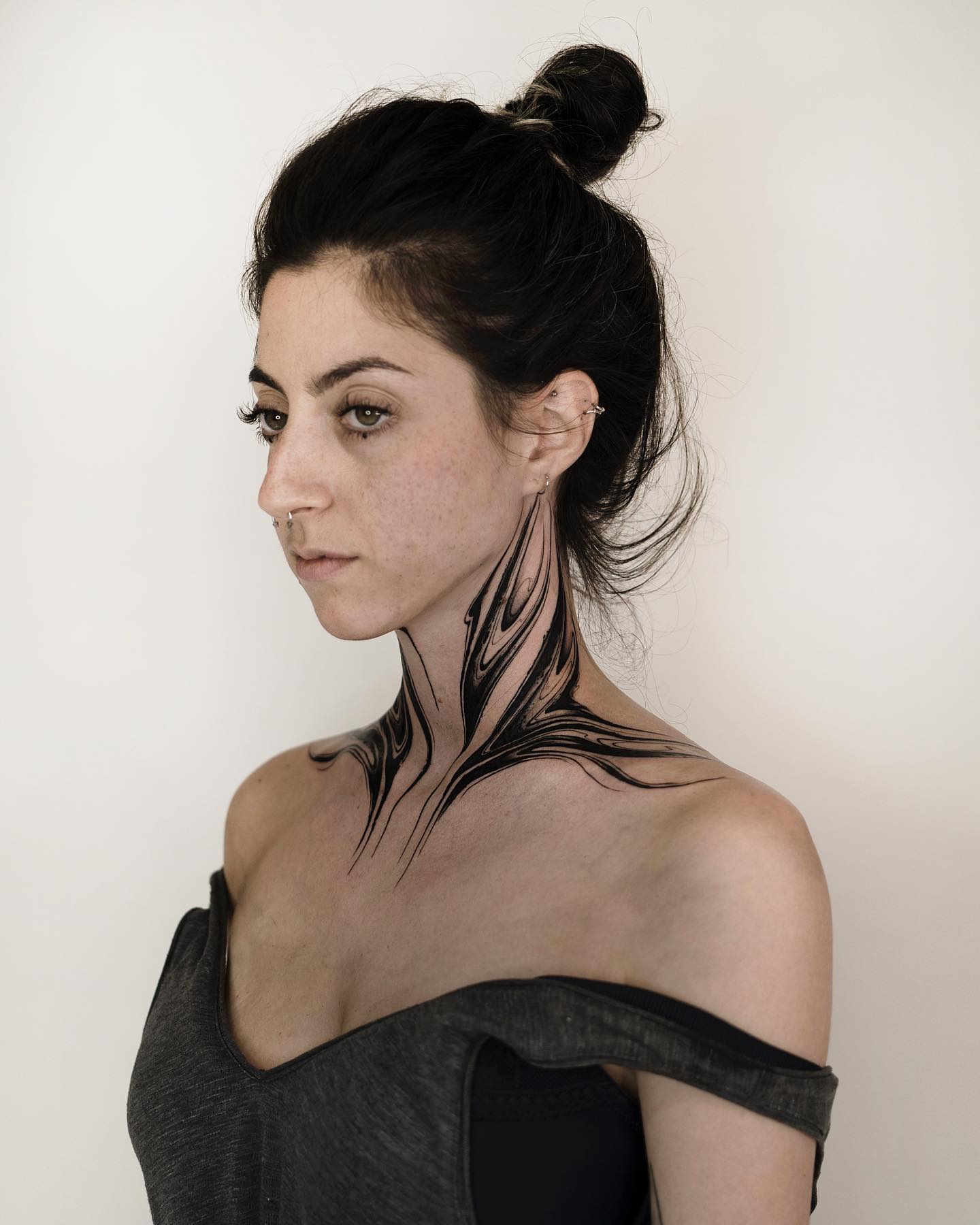A badass wing tattoo that stretches out to your collarbone. Along with some simple but good-looking lineworks, this tattoo forms a nice piece. Give this stylish throat tattoo a shot.
