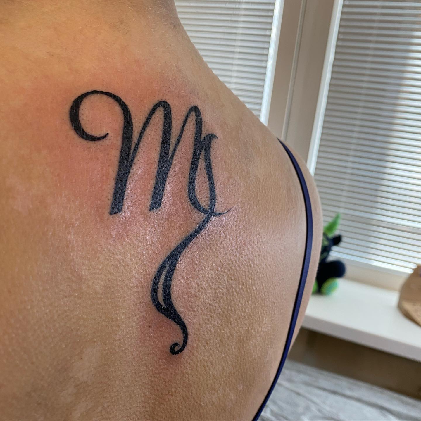 Here is an another Virgo sign tattoo on back. The line that grows longer downwards helps this tattoo achieve an elegant look.