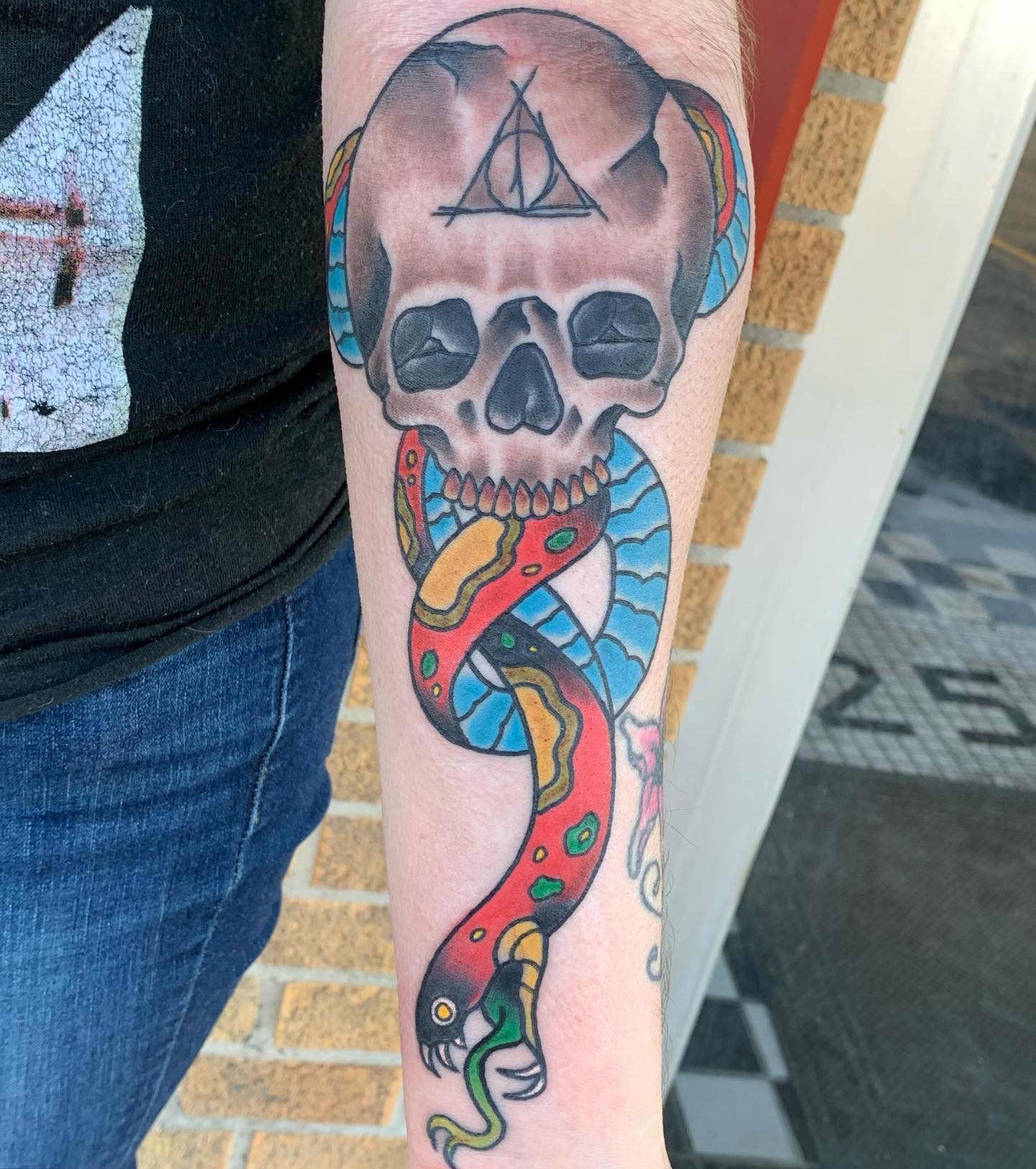It looks like the tattoo artist has done an amazing job of turning the death eater into a colorful, friendly thing. Blue, red, yellow and green colors make this death eater shine out.