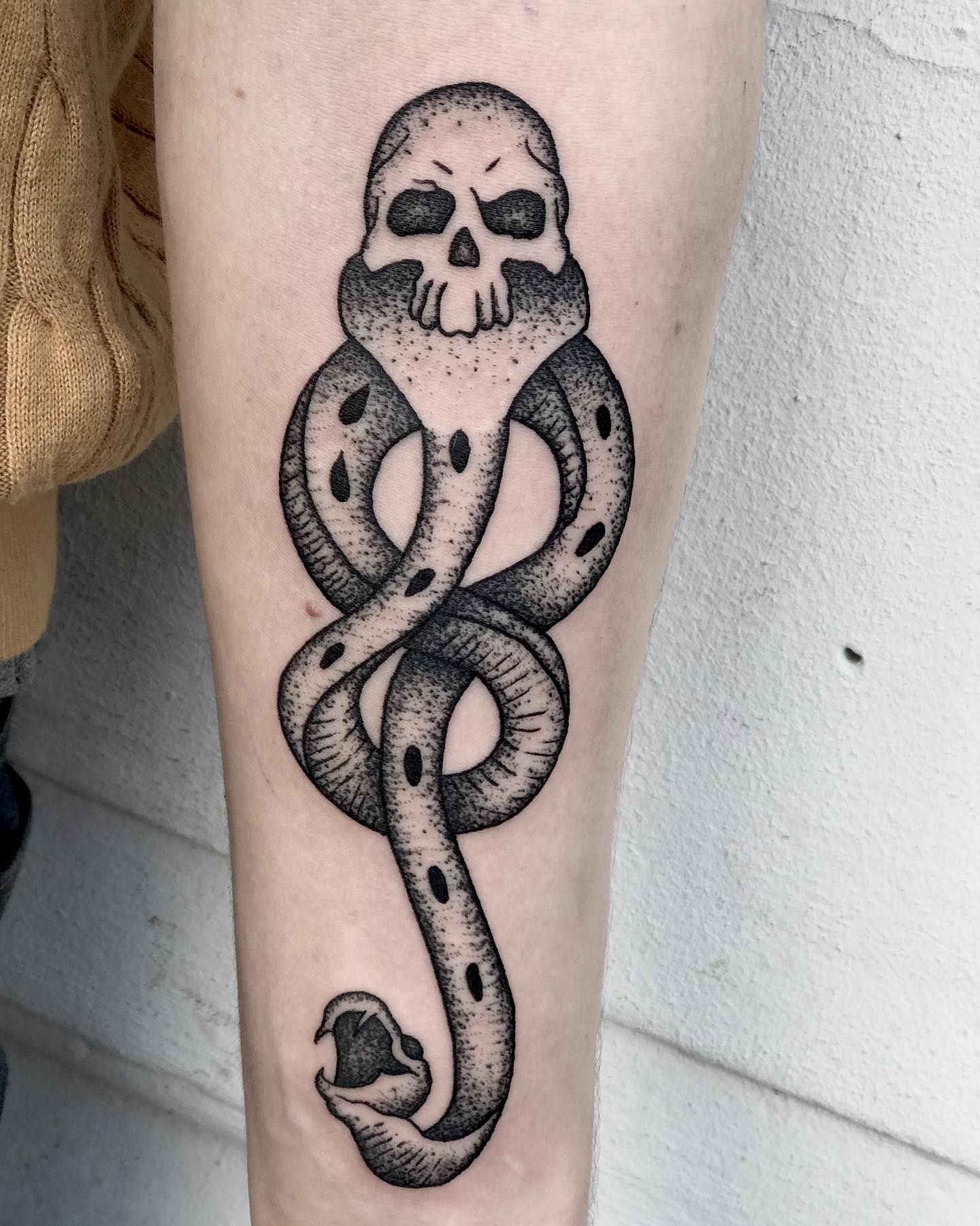 In this death eater tattoo, dotwork technique which is about filling dots to give a shading effect. This tattoo is usually used to symbolize the dark side of magic, or the fact that someone has been touched by Voldemort's powers.