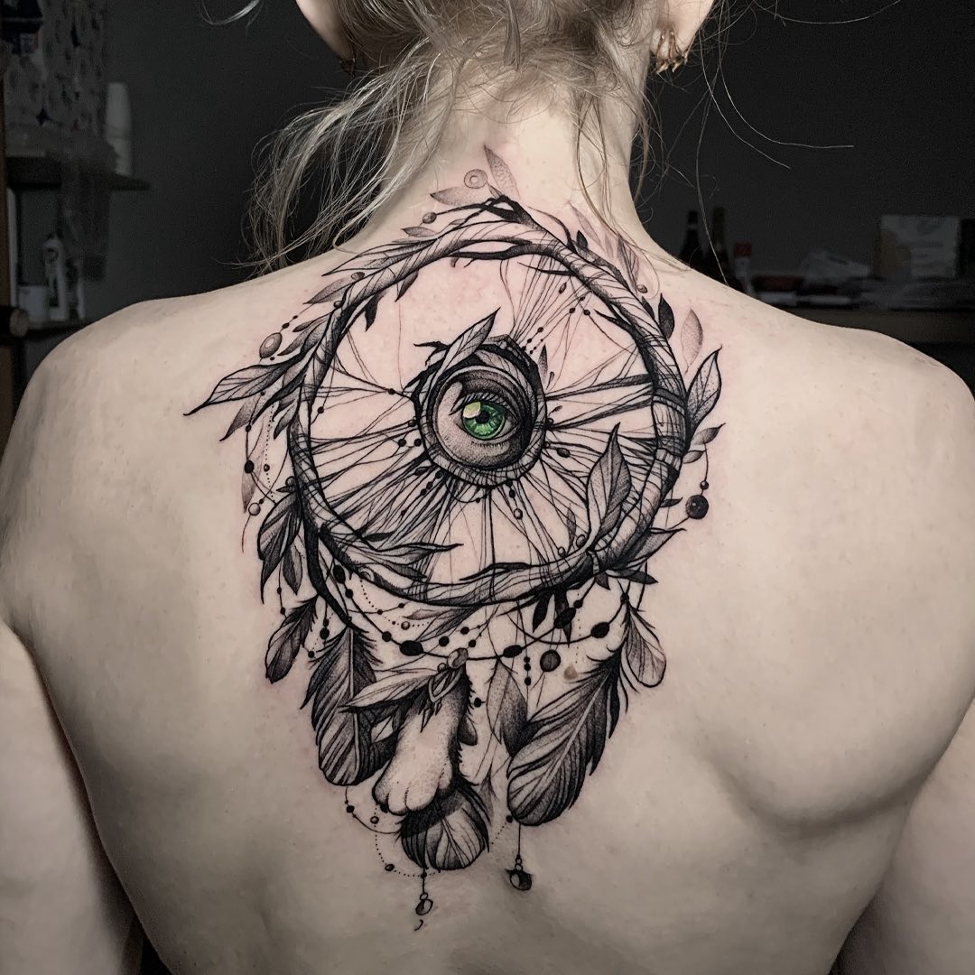 Are you ready to turn your back into a piece of art? Then, a dream catcher with an eye in the center is for you! A dream catcher tattoo with an eye in the center is a symbol of protection. The eye represents the watchful and protective spirit of the guardian angel.