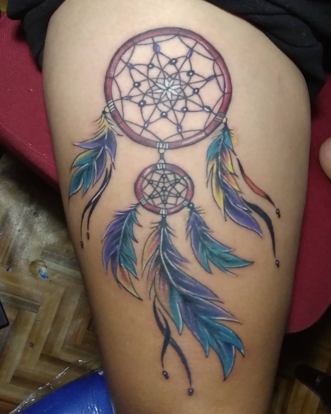 Brave tattoo lovers will adore this dream catcher tattoo! All you need to do is being ready to have your upper leg cover up. This big size and gorgeous dream catcher is ready to make you feel adorable with its colorful feathers.