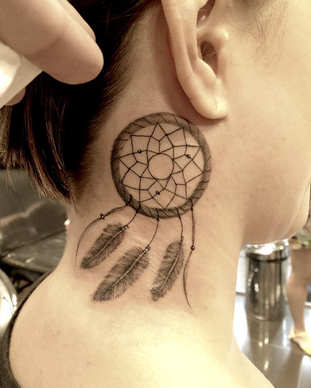 A dream catcher tattoo behind the ear is a popular tattoo these days. It's usually done in black ink, and it can be done in a variety of styles depending on the artist. The dream catcher itself is usually small, with intricate patterns and designs surrounding it, so let's go and get it!