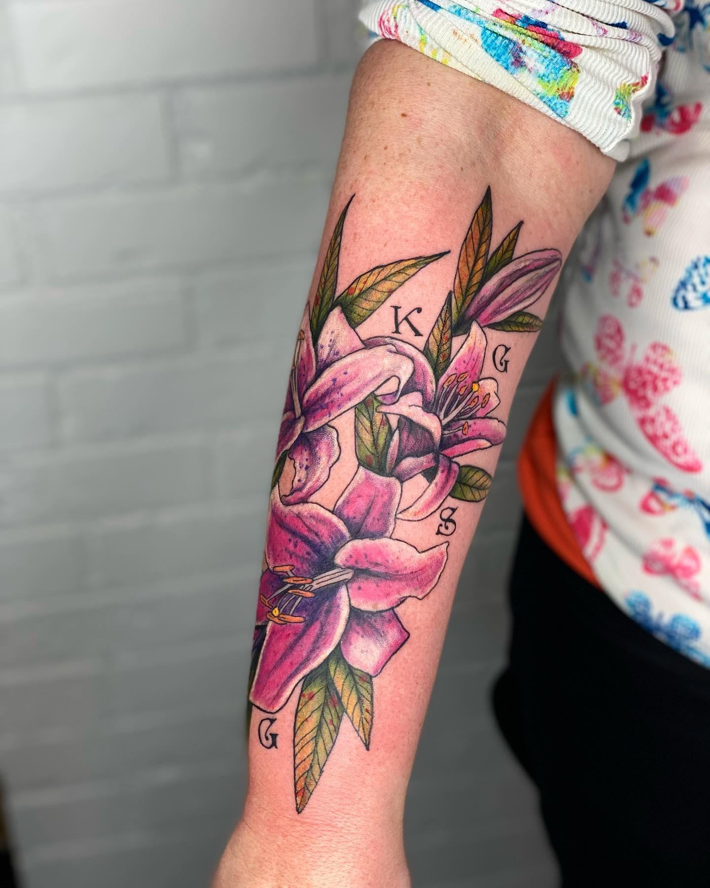 The pink lily is a flower that symbolizes faithfulness and purity. A pink lily tattoo can be used by people who want to convey their love for another person, even if they're not married or engaged yet. If you want to convey this message, go for this tattoo with green leaves.