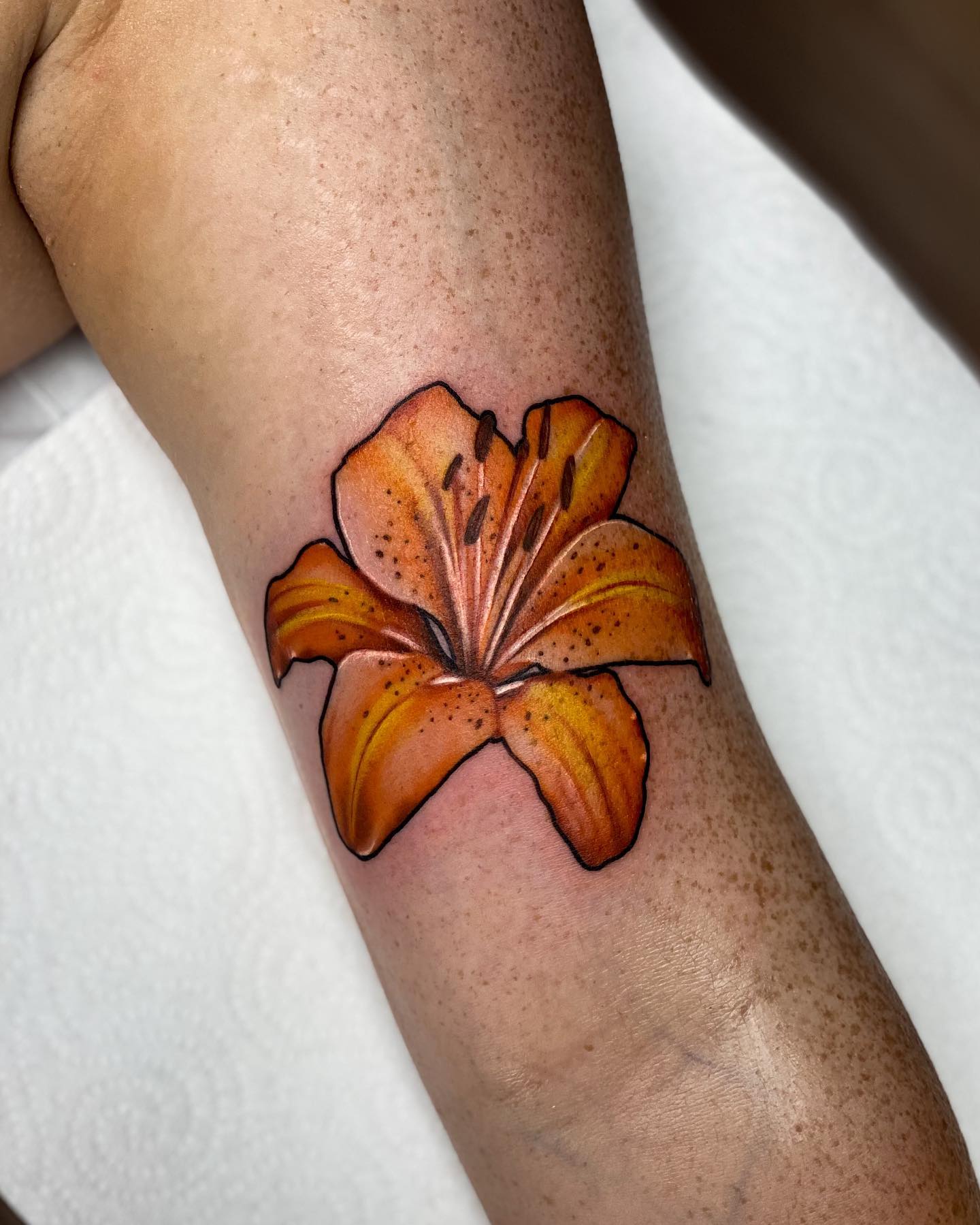 The plain orange lily tattoo is a beautiful symbol of purity and optimism. Those who want a simple lily tattoo will definitely fall in love with this! Go and get it on your arm as soon as possible!