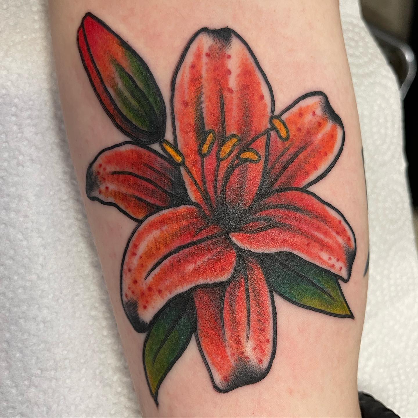 The red lily is a beautiful flower that has been used in art for centuries. Then, why don't you use it on your body? Plus, a red lily has a long history as a symbol of love and devotion.