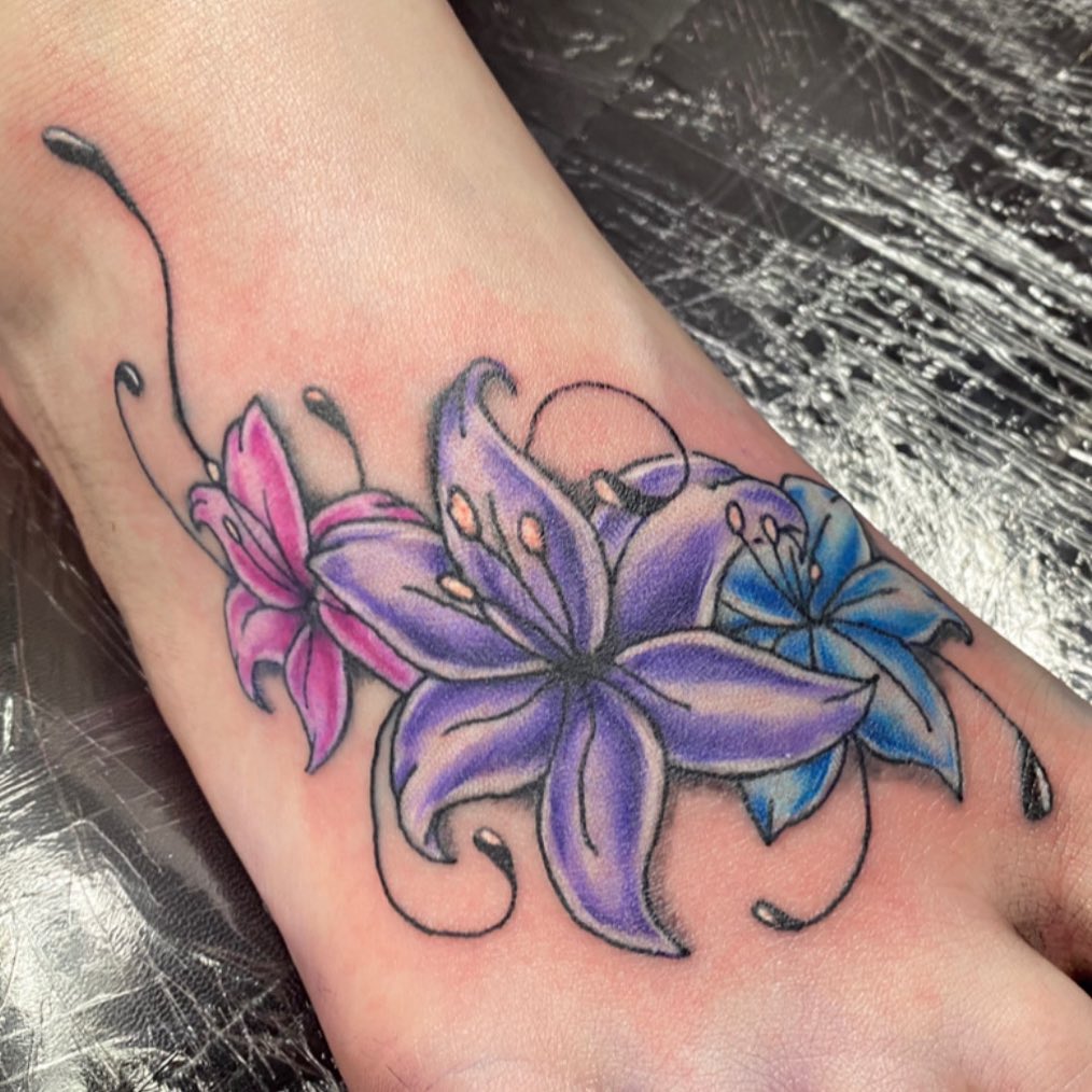 Pink, purple and blue lilies are combined together to create a unique design here. Purple lily is a symbol of hope while pink lily is associated with femininity and romance. Plus, blue lily represents purity, spirituality and calmness.
