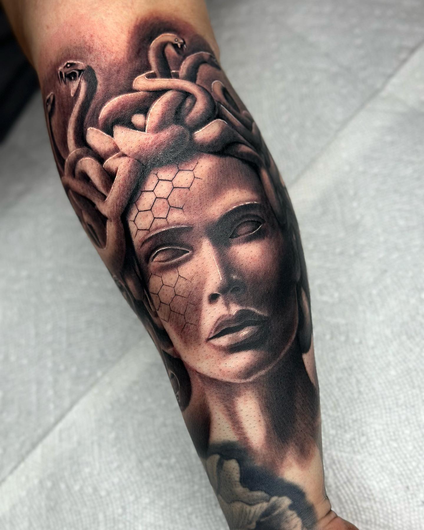 Depicted as a fierce and repulsive woman, Medusa has a strong look on statues. Covering up your arm with a Medusa statue sounds like a great idea, doesn't it? The dark shades give it a realistic look, too.