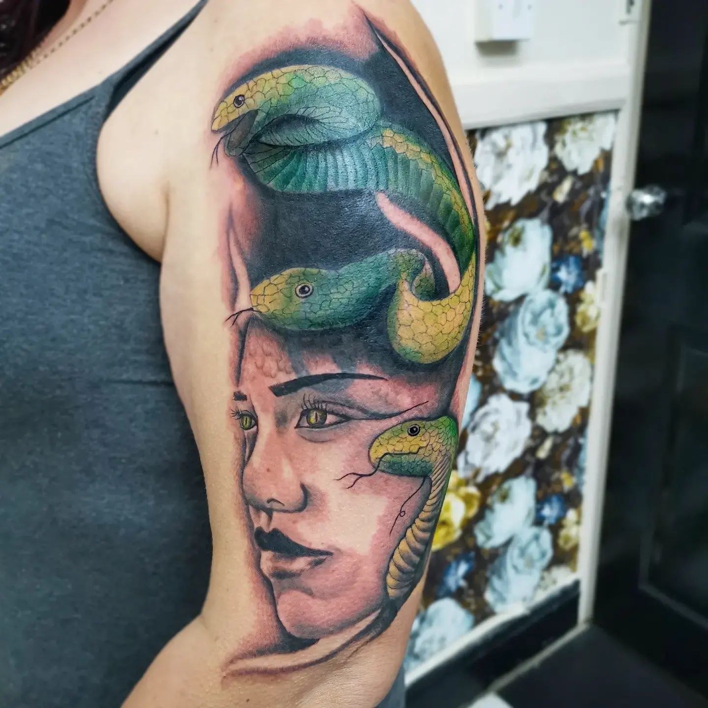Are you for cover up tattoos? Here is an another Medusa design that stretches to your elbow from your shoulder. The bright-colored snakes are ready to catch your attention easily with different shades of green.