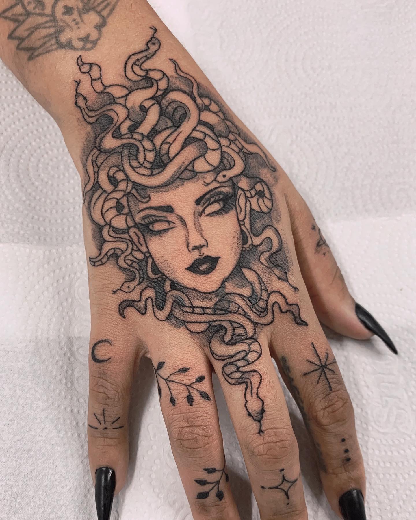 Hand tattoos take a lot of courage because it's almost impossible not to see it every time. If you have made your decision to get a tattoo on your hand, one of the best tattoo designs is definitely a medusa face.