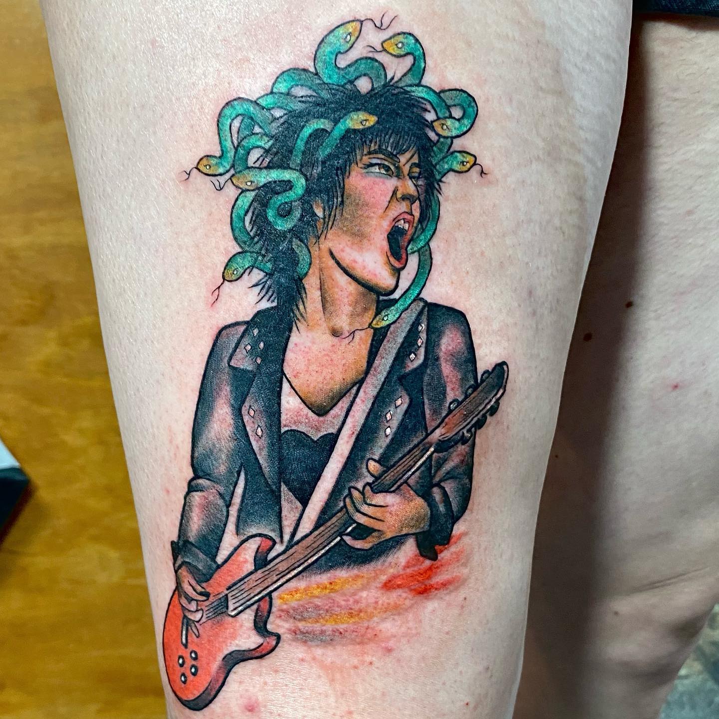Creative tattoos are always a favorite, right? Rock goddess sounds quite sexy and in this tattoo, Medusa is a rock story and she is playing a bass guitar. With her black leather jacket, Medusa will give you a rock star feeling.