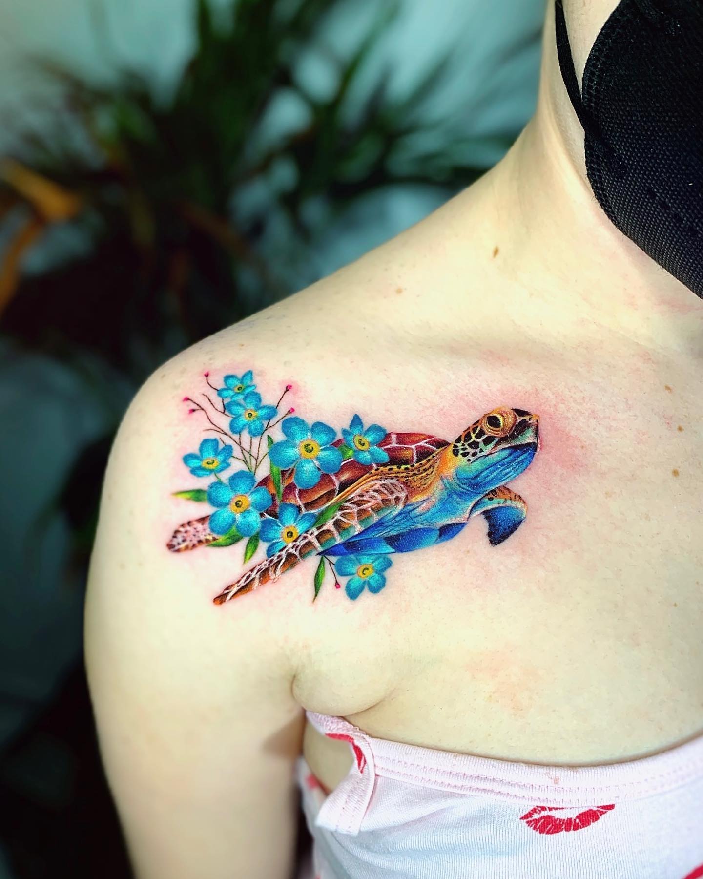 To cheer up your shoulder with something colorful, there is no better tattoo than a sea turtle. Blue flowers that are added on the shell look quite amazing. The colors and the way it looks like it's swimming through water with flowers are ready to warm your heart.