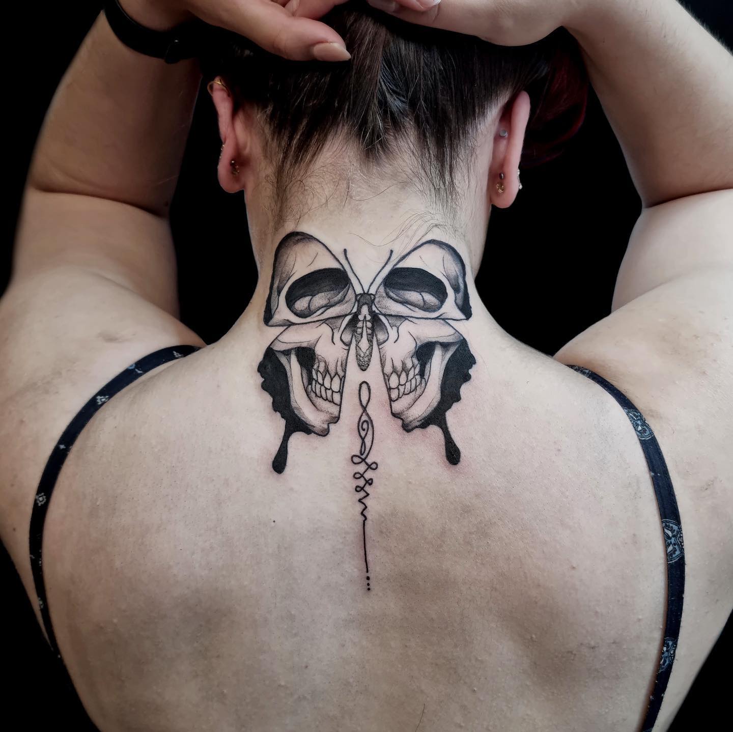 Butterfly skull neck tattoo back