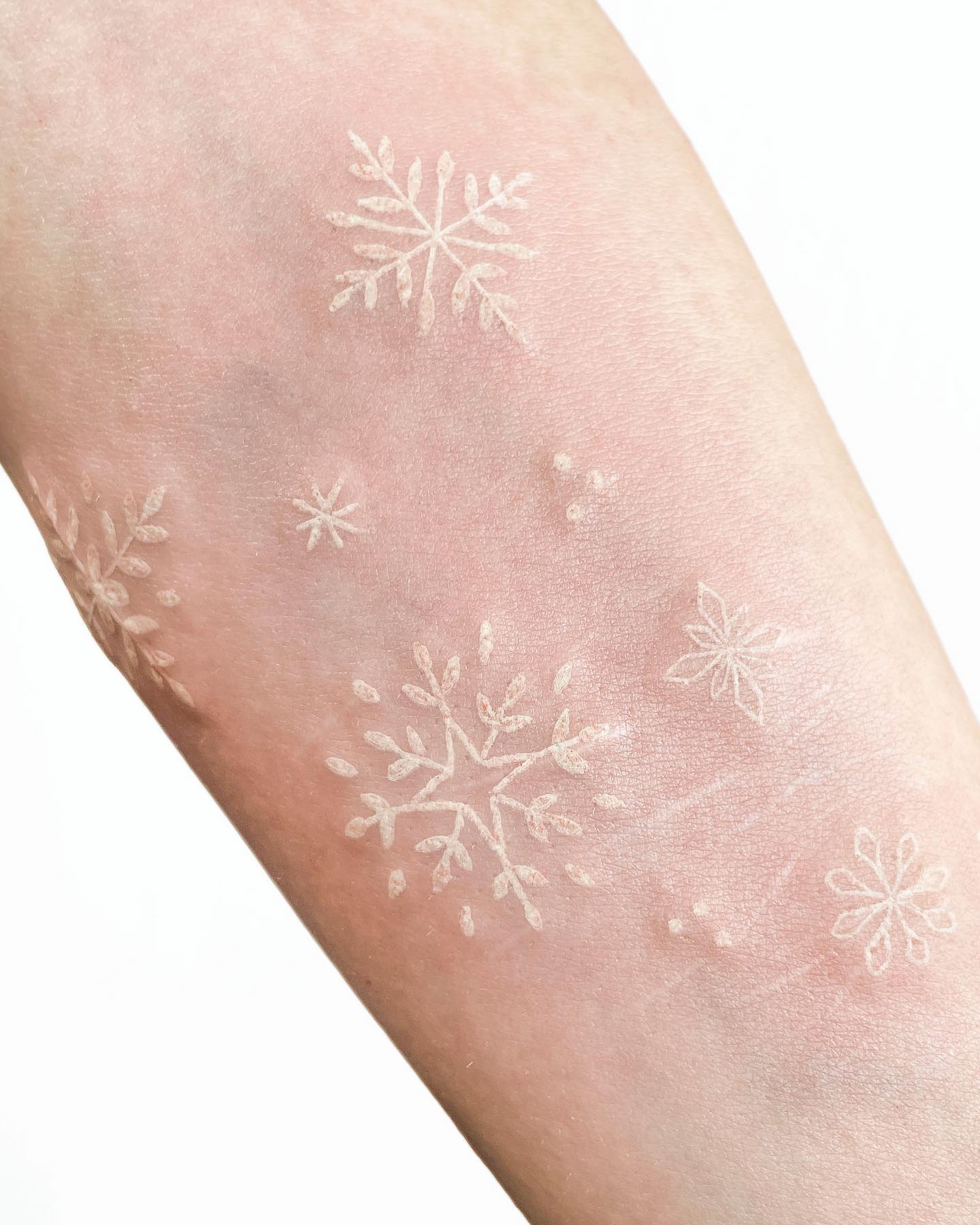 Snowflake white ink tattoos are so beautiful! They have a magical, wintery feel to them. The shimmering white ink makes the tattoo look like snowflakes falling down your arm, which is amazing.