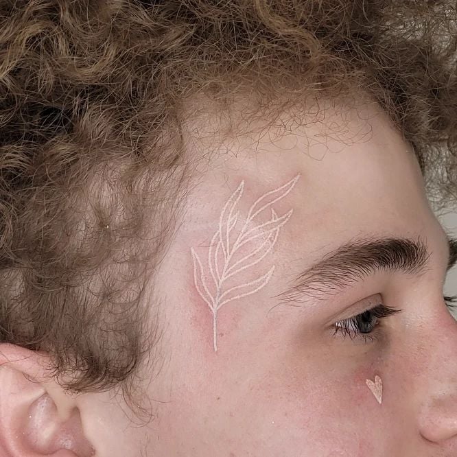 Leaf tattoos are a great way to show your love of nature to everyone. If you want to get a white ink tattoo on your face, getting a white leaf tattoo above your eyebrows is definitely for you!