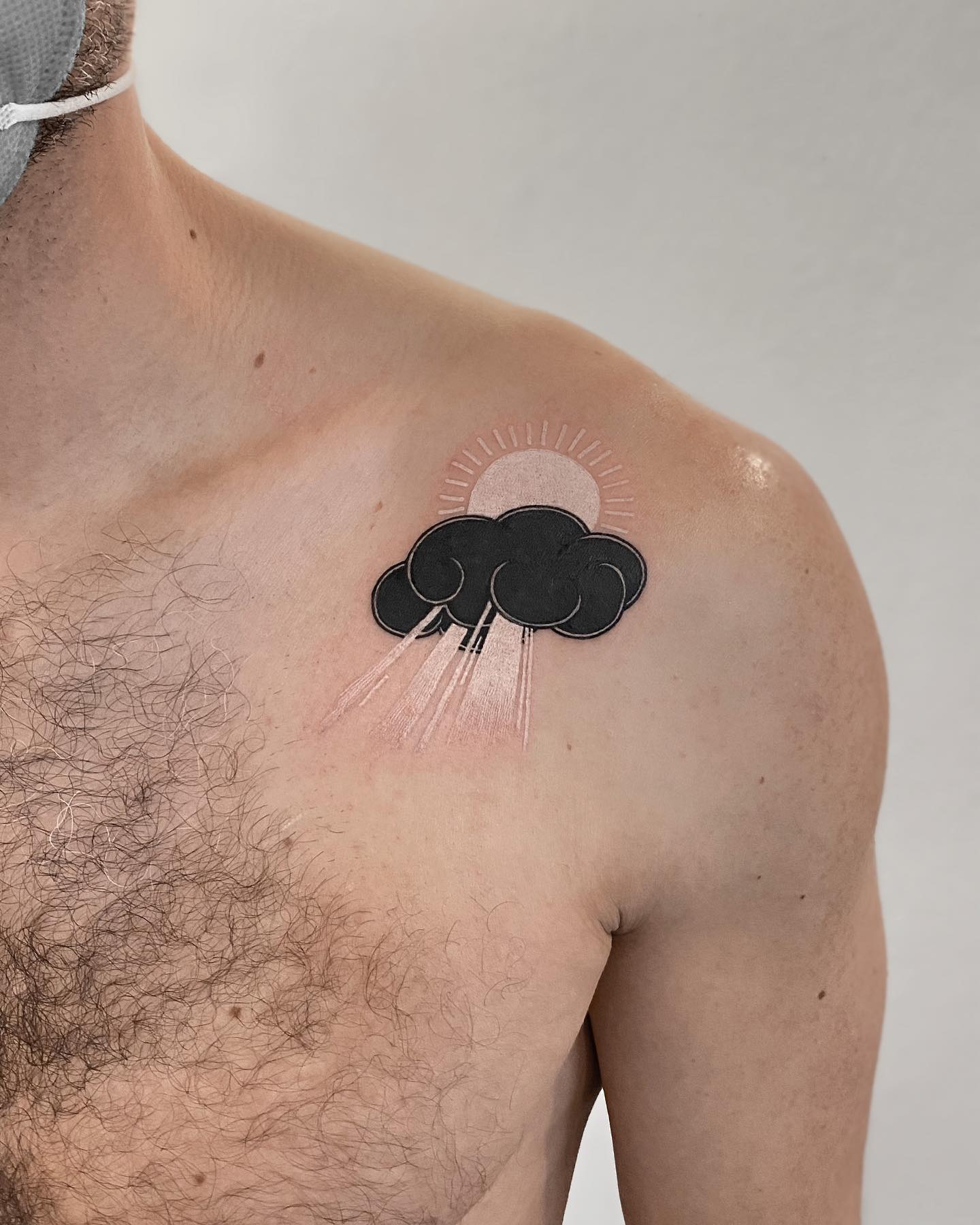 A sun tattoo is a constant reminder of how powerful the sun is and how lucky we are to live on a planet where we get to enjoy it every day. Let's get it with a white ink and apply a black cloud to make the sun stand out.