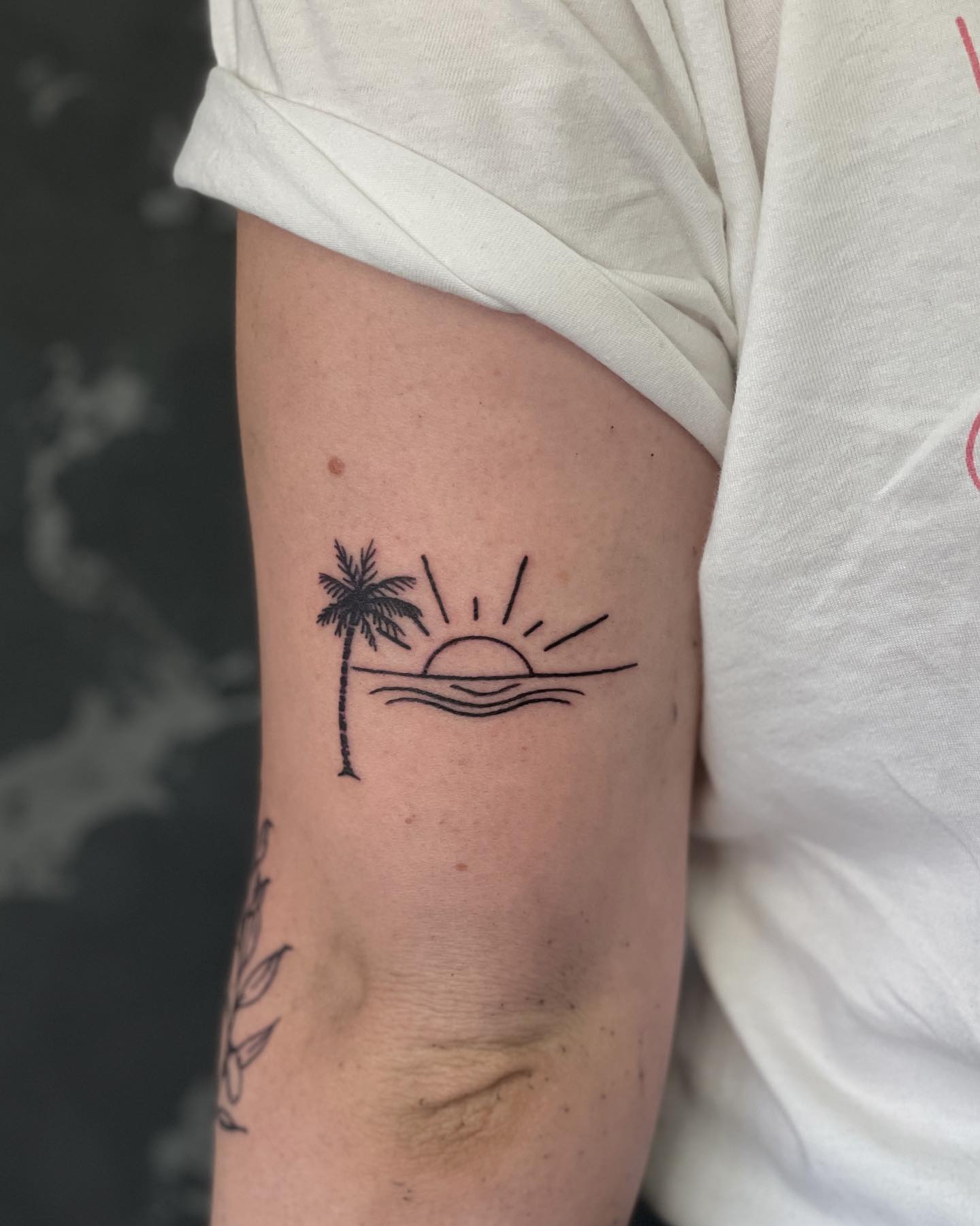 Minimalist sunset tattoo on the inner arm